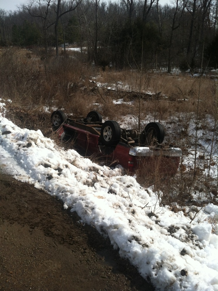 Flipped truck on side of road