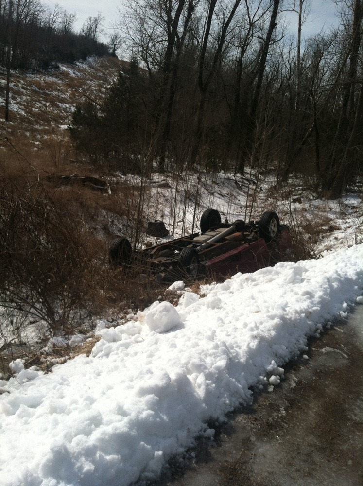 Flipped truck on side of the road