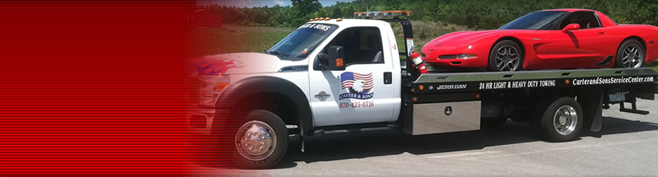 Image of a car being hauled on a flat bed.